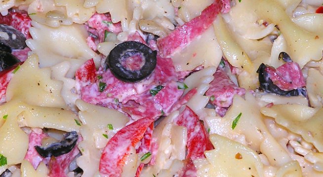500 г макарони, формичките вие си избирате
една по-голяма глава лук
2-3 пресовани скилидки чесън
2 по-големи домата
7-8 кисели краставички
около 10 маслини
300 г колбас, кренвирши, шунка или печено месо, каквото имате под ръка
няколко стръка магданоз
сол и черен пипер на вкус
За соса:
1 и 1/2 кофичка кисело мляко
една кофичка майонеза