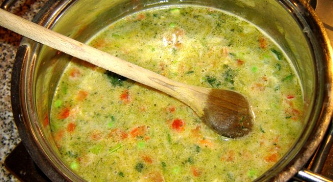 500 г коприва
1 корен праз
1 ч. ч. ориз
1 к. ч. домати консерва
4 с. л. олио
1 яйце
1 кубче зеленчуков бульон
кисело мляко по желание
