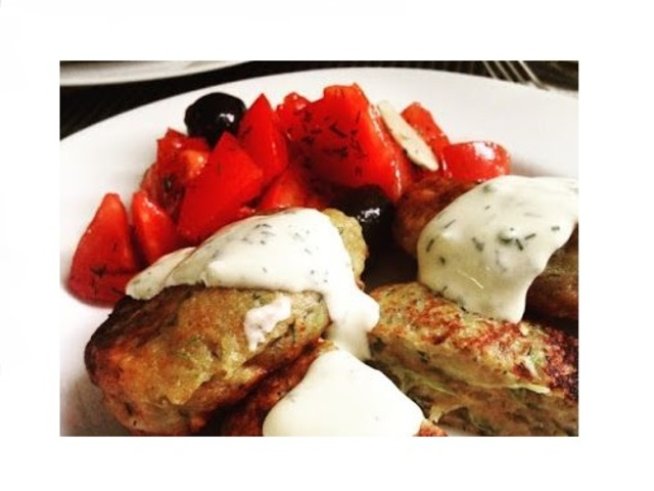 1 голяма тиквичка
50 г  козе сирене
2 скилидки чесън
2 яйца
2 с.л. галета
1/2 връзка копър
1 бакпулвер
черен пипер

За чесновия сос:

3 с.л. майонеза
4 с.л. цедено кисело мляко
1/2 връзка копър
1 ч.л. зехтин
3 скилидки пресован чесън
