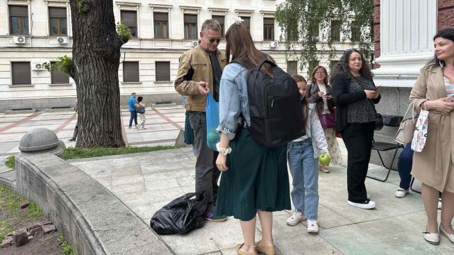 Юлиан Вергов раздава ябълки пред Народния театър. Снимка: Народен театър