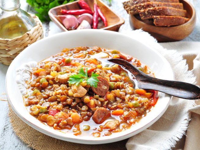 2 чаши леща
2 глави лук, нарязани
2 моркова
2 наденици, нарязани
1 и ½ л зеленчуков бульон, разтворен
3 скилидки чесън, намачкани
2 стръка целина
1 малка консерва белени домати
2 щипки сол
2 щипки черен пипер
2 щипки чубрица, едро смляна 
1 чаша бяло вино
1 дафинов лист
½ чаша настърган пармезан
2 супени лъжици зехтин