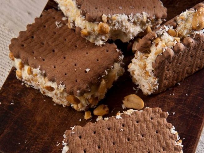 1 пакет шоколадови бисквити
300 г ванилов сладолед или друг по ваш избор
50 г белени фъстъци или други ядки по ваш избор
кокосови стърготини