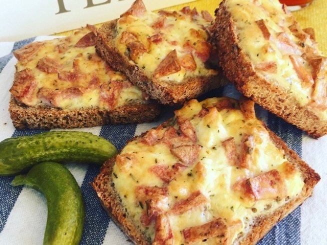 12 филии черен хляб
1 кренвирш
100 г сирене
2 яйца
1 с.л. майонеза
черен пипер
чубрица
масло