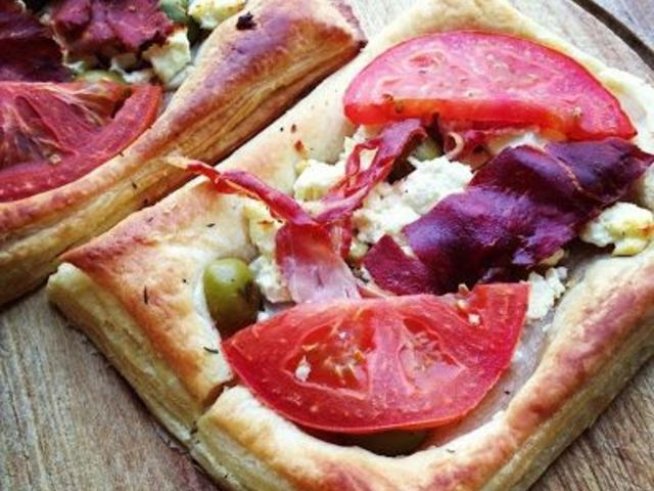 1 пакет бутер тесто
150 г краве сирене
няколко ленти прошуто
10 зелени маслини без костилка, нарязани наполовина
3-4 скилидки чесън нарязан на ситно
1 домат
зехтин
ронена чубрица