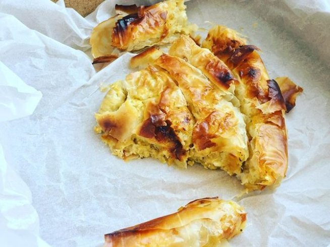 1  пакет кори за баница 
2 яйца
50 г  разтопено краве масло
1  малка глава лук 
4-5  малки тиквички 
200 г  краве сирене 
½  връзка пресен магданоз 
2  скилидки чесън 
босилек
черен пипер 
сол
зехтин