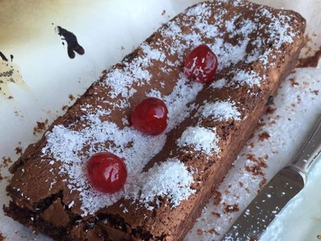 1  малка тиквичка 
1  ч.ч. кафява захар
1  с.л. какао
1  бакпулвер
2  с.л. олио
1 ½  ч.ч. брашно
100 г  млечен шоколад
100 г  цели лешници
кокосови стърготини