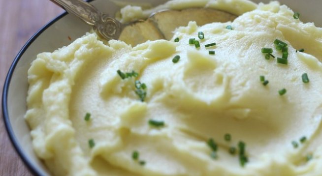 2 кг картофи, обелени, нарязани
150 г масло
сол и черен пипер на вкус
1 чаша заквасена сметана
1 и ½ до 2 чаши топло прясно мляко
2 супени лъжици ситно нарязан пресен лук