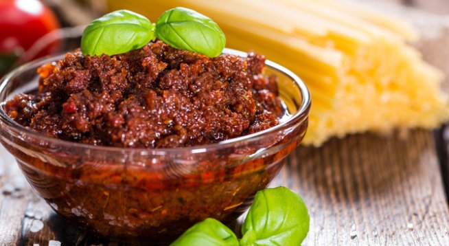 150 г домати в зехтин, отцедени
5 листа пресен босилек
3-4 бадема
1/2 супена лъжица кедрови ядки
1 стрита скилидка чесън
1/4 ч.ч. прясно настърган пармезан (25 г)
1/2 ч.л. риган
75 мл зехтин