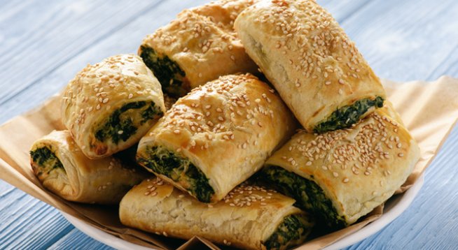 2 супени лъжици зехтин
1-2 скилидки чесън, пресован
250 г спанак
Сол на вкус
100 г фета сирене
2 листа бутертесто
1 яйце
1 супена лъжица прясно мляко
Сусам за поръсване