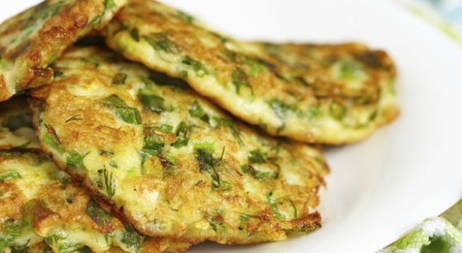 1 кг тиквички, настъргани
сол на вкус
¼ чаша настърган пармезан
2 яйца
2 стръка пресен лук, ситно нарязан
3 скилидки чесън, намачкани
4 листа босилек, нарязани
1 щипка индийско орехче
1 щипка чеснова сол
черен пипер на вкус
1 супена лъжица масло
1 чаена лъжичка зехтин