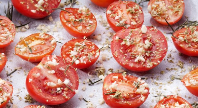500 г чери домати
нарязани на ситно свежи листа босилек, на вкус
50-100 г настърган пармезан
1 стрита скилидка чесън
зехтин за поръсване, около 2-3 с.л.