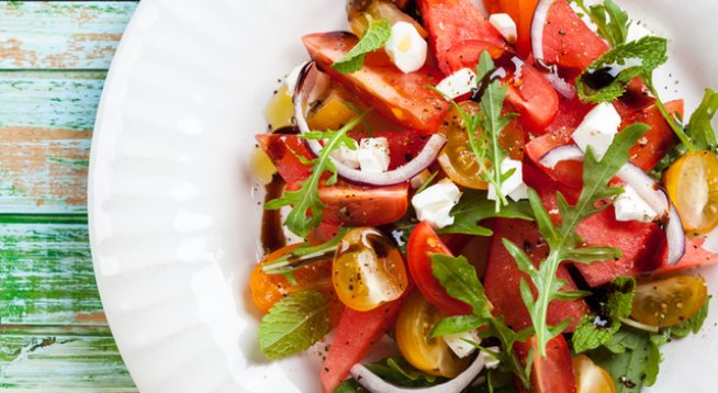 3 супени лъжици зехтин
2 чаени лъжици бял балсамов оцет 
½ чаена лъжица сол 
300 г смес от различни видове домати
3 чаши рукола 
1 чаша нарязан червен лук
300 г диня, нарязана на кубчета
150 г фета сирене, натрошено 