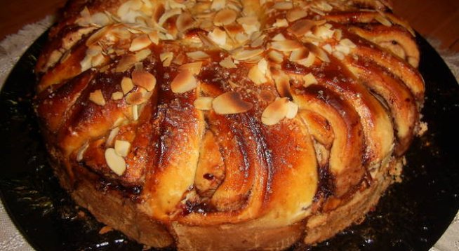 4 яйца (единият жълтък е за намазване на козуначената пита преди печене)
пакетче суха мая на Д-р Йоткер
250 мл прясно мляко
150 г захар
50 г чисто масло
2 лъжици олио
щипка сол
една ампула ванилия
750 г брашно тип 450
сладко от горски плодове
филирани бадеми
