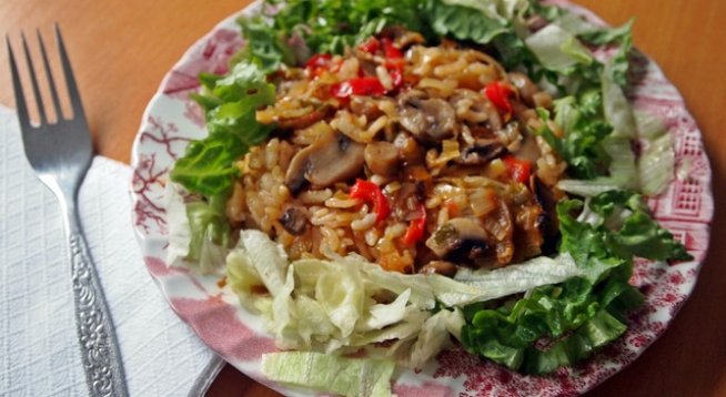 300 г гъби печурки
2 ч.ч. ориз
2 червени чушки - пресни или 3 сухи
2 стръка праз лук
магданоз
олио
сол
черен пипер