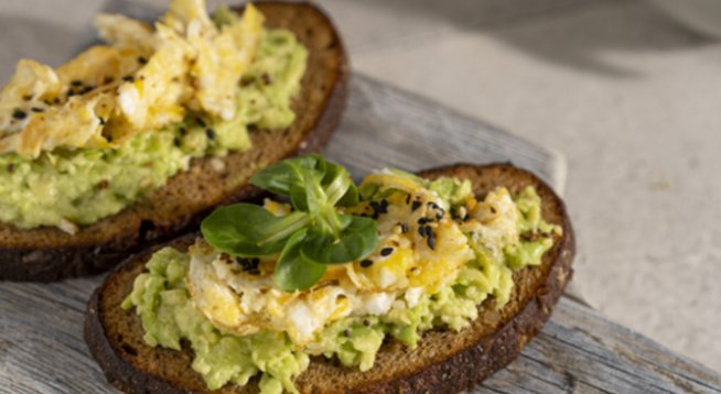1 супена лъжица олио
2 големи яйца
Сол и черен пипер на вкус
2 филии хляб
1 супена лъжица меко масло
100 г чедър, настърган
½ авокадо, намачкано