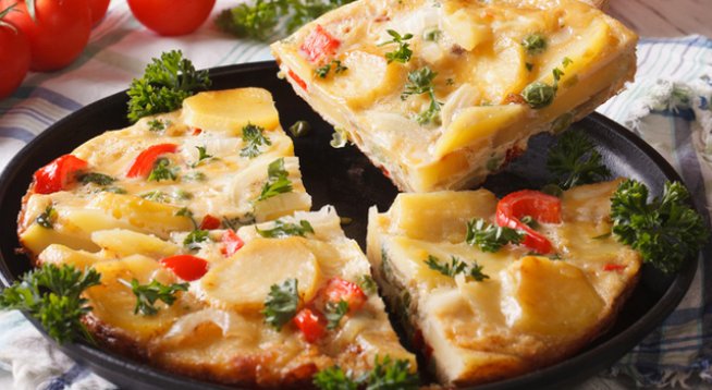 400 г пресни картофи, нарязани
150 г грах
4 супени лъжици олио
1 глава лук, нарязана
2 скилидки чесън, пресовани
6 големи яйца
4 супени лъжици пресен магданоз
200 г шунка, нарязана
6 бр. чери домати на четвъртини