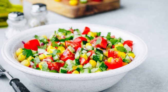 1 консерва сладка царевица, отцедена
500 г чери домати на половини 
1 краставица, нарязана на малки парчета 
1 авокадо, обелено и нарязано на кубчета
1 малка глава лук, ситно нарязан 
¼ връзка кориандър или магданоз, ситно нарязан 
2 супени лъжици зехтин
Сокът от 1 лайм или лимон 
Сол и черен пипер на вкус 