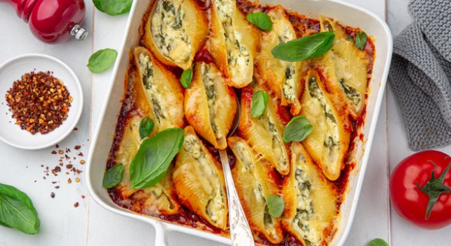 350 г паста големи мидички
Сол на вкус
2 супени лъжици зехтин
1 връзка пресен лук, ситно нарязан
4 скилидки чесън, пресован
300 г спанак
½ чаша пресен магданоз, ситно нарязан
½ чаша пресен копър, ситно нарязан
2 яйца, разбити
½ чаша рикота
450 г сирене, натрошено
Черен пипер на вкус
680 г (1 буркан) готов сос маринара или доматен сос
1/3 чаша настъргана моцарела