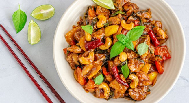 2 бр. пилешки гърди без кост и кожа
1 щипка сол и черен пипер на вкус
1 супена лъжица царевично нишесте
½ чаша студена вода
Сокът от 1 лимон
1 и ½ супени лъжици оризов оцет
1 супена лъжица кетчуп
1 супена лъжица соев сос или на вкус
1 супена лъжица кафява захар
2 чаени лъжици азиатски чили сос (готов)
2 супени лъжици олио
1 прясна люта чушка, нарязана
6 тънки резена пресен джинджифил
½ чаша кашу, печено
2 скилидки чесън, пресован
¼ чаша пресен магданоз или кориандър, ситно нарязан