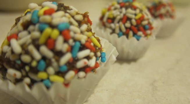 Продукти за около 8-10 бонбона:
кората и сока на 1/2 лимон
3 суп. лъж. стафиди
2 суп. лъж. червени боровинки
3-4 сушени кайсии
1 лъжица мед
захарни пръчици за овалване