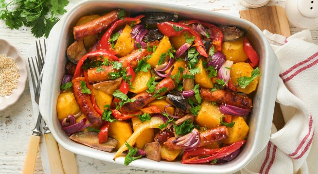 Печена наденица с картофи, лук и чушки