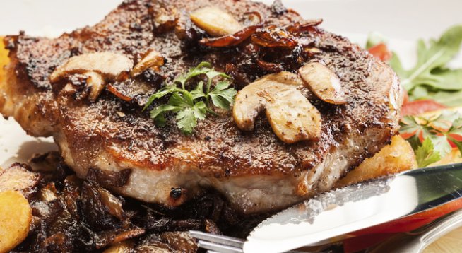 4 свински пържоли
сол и черен пипер на вкус
щипка чесън на прах или на гранули
1 глава лук, нарязана
400 г пресни гъби, нарязани на филийки
кубче гъбен бульон
200 мл течна готварска сметана