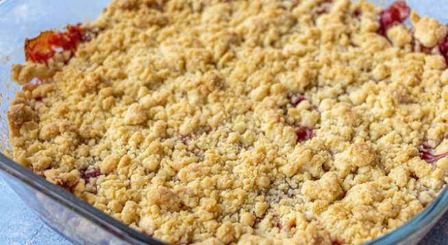 2 праскови, нарязани
1 ябълка, обелена и нарязана
1 круша, обелена и нарязана
75 г боровинки
75 г череши, нарязани и без костилки
2 сини сливи, нарязани
1 яйце
150 г захар
4 супени лъжици прясно мляко
100 г брашно
1 чаена лъжица бакпулвер
½ чаена лъжица сол
½ чаена лъжица ванилия
30 г масло, разтопено