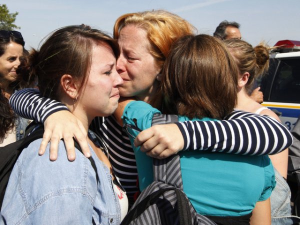 Майка целува дъщерите си след като е разбрала, че е можело да ги загуби в атентат в училище. Снимка: Reuters