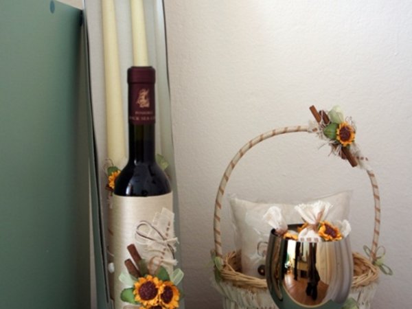 Отново букет изкуствени мини слънчогледи урасяват червеното вино, свещите и бокала за църковния ритуал.