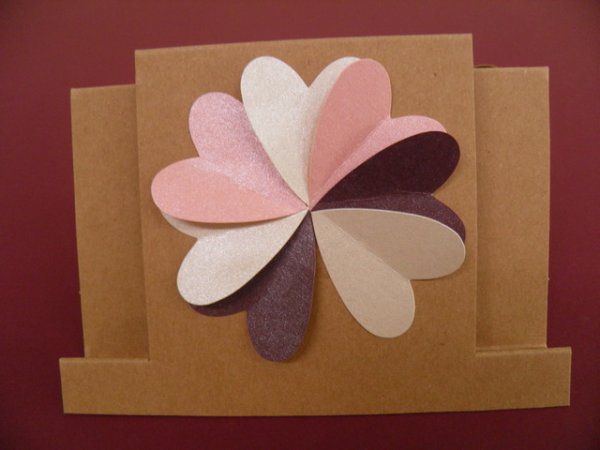 Тази картичка е направена от 7 сърца от перлен картон. Всяко сърце е сгънато по средата, след което са подредени във формата на цвете. Лесно и ефектно!